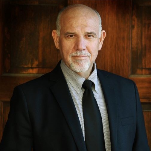 Alan Blumenfeld wearing a black suit and tie