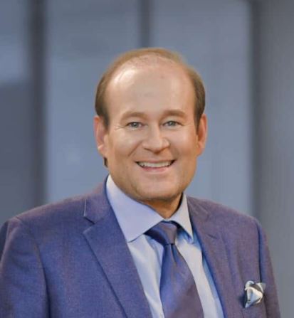 Joel Bieber wearing a blue suit.