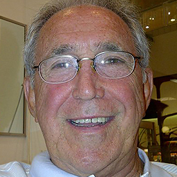 Close of picture of a man with short gray hair and wearing metal rimmed glasses.