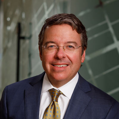 Jason Konvicka in blue suit with gold tie