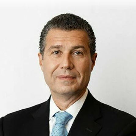 Antonio Romanucci wearing a black suit and light blue tie.