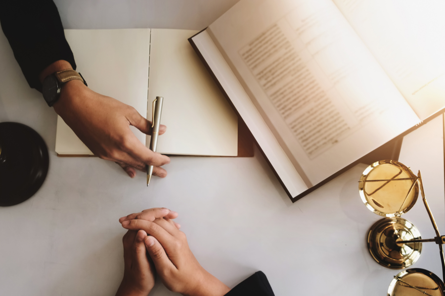 Hands on a table with two books