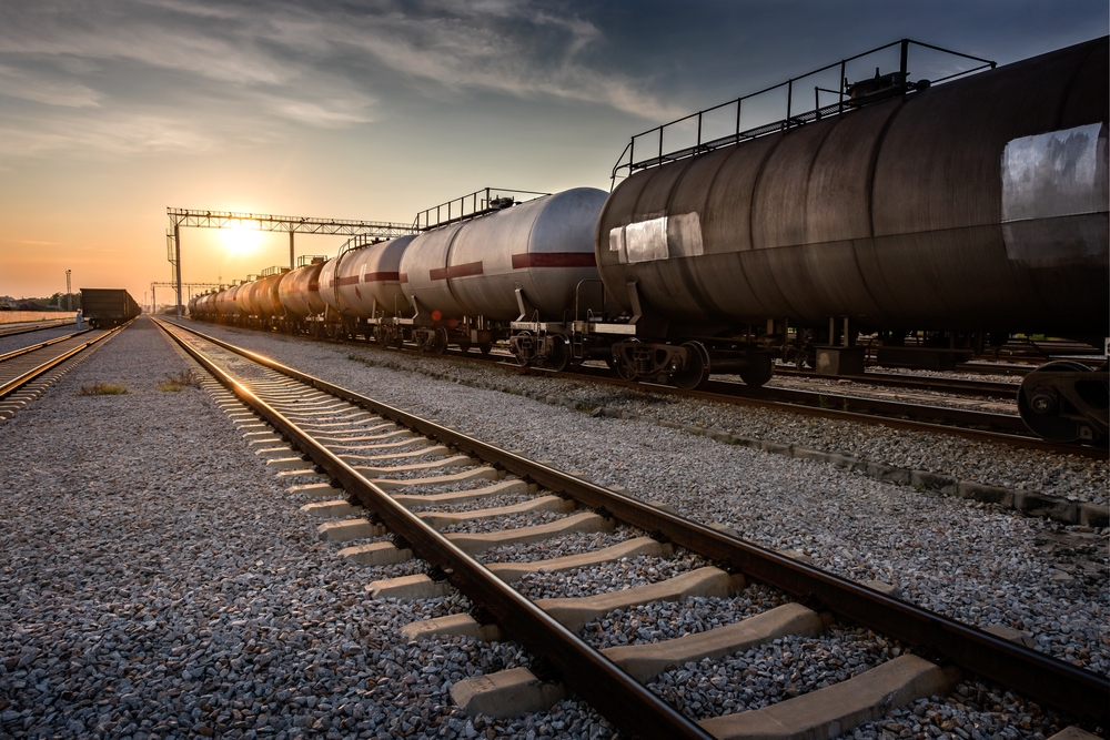 A freight train at a station with three parallel train tracks